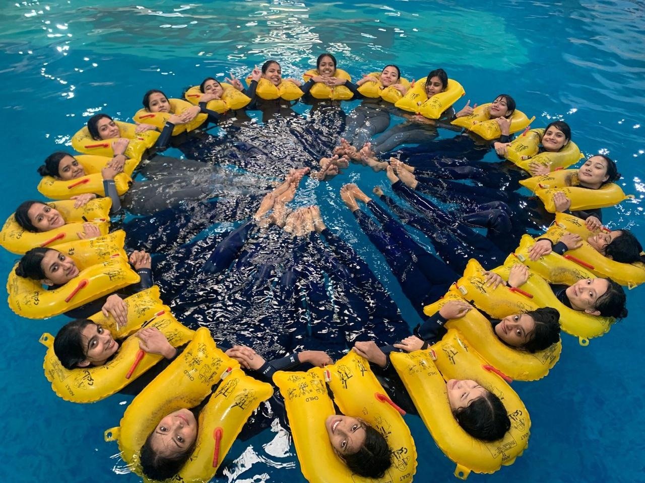 Students in life vests during a water survival drill in the training pool